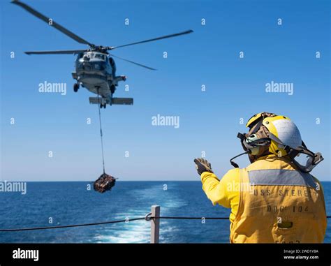 Atswain S Mate Signals To An MH 60R Sea Hawk Helicopter To Position And