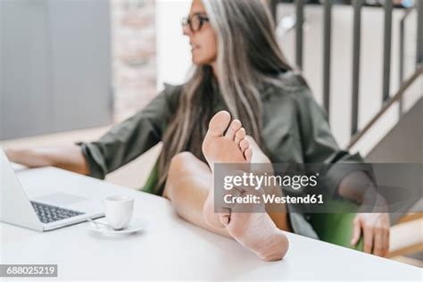 Woman Working In Office With Bare Feet On Desk High Res Stock Photo