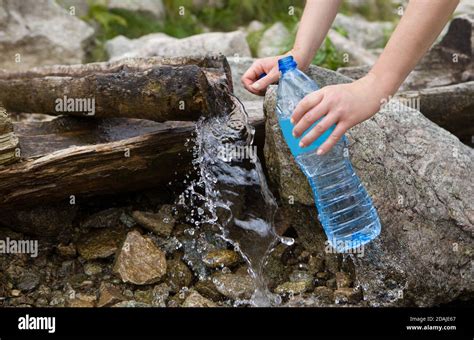 Taking spring water from a mountain spring. Plastic bottle water ...