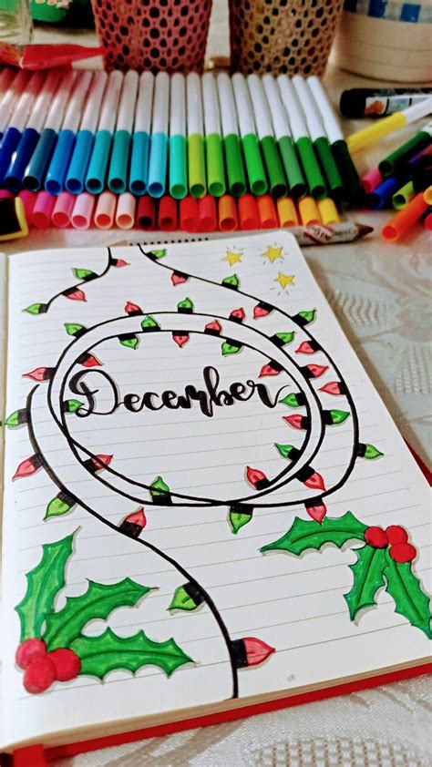 A Notebook With The Word December Written On It Next To Crayons And Markers