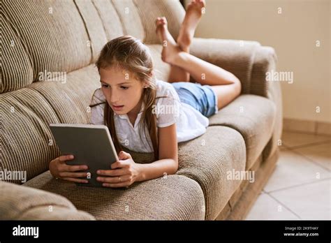 Learning In The New Age A Focussed Young Girl Browsing On A Digital