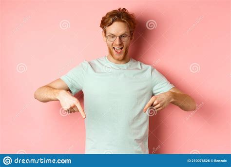 Handsome Caucasian Man With Red Messy Hair And Glasses Pointing