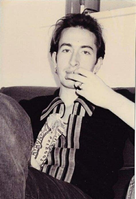 Black And White Photograph Of A Man Sitting On A Couch With His Hand In