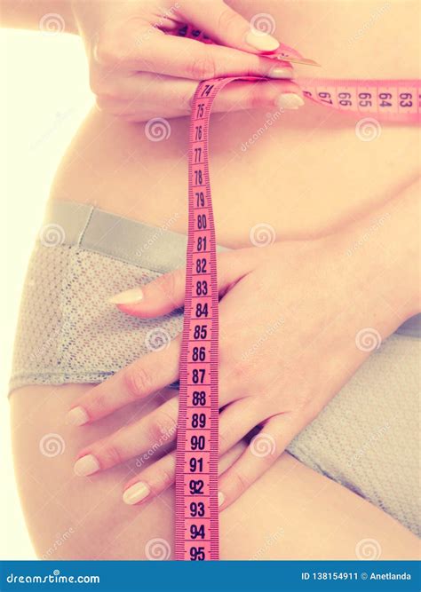 Woman In Lingerie Measuring Her Waist With Measure Tape Stock Image