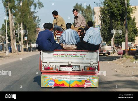 Men squeezed into a pickkup truck ride through a provincial town in the ...