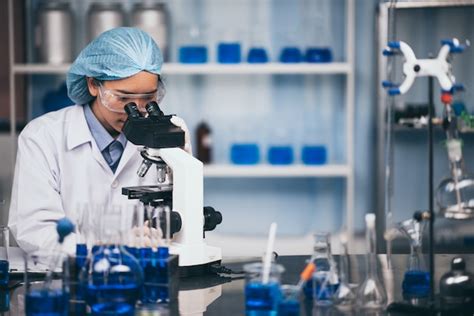 Joven Cient Fico Mirando A Trav S De Un Microscopio En Un Laboratorio