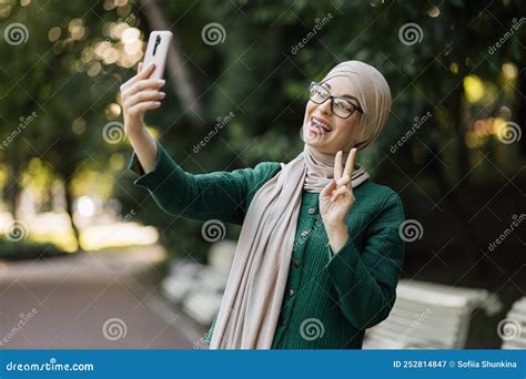 Portrait Of Smiling Happy Beautiful Muslim Woman Relaxing Using Digital