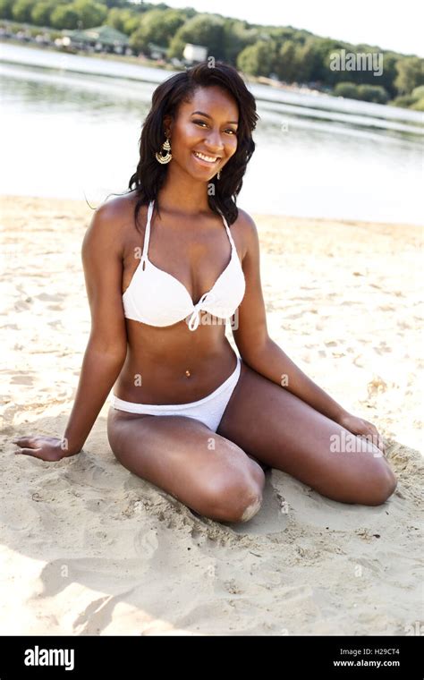 Schöne Mädchen am Strand in ihrem Bikini sitzen Stockfoto Bild