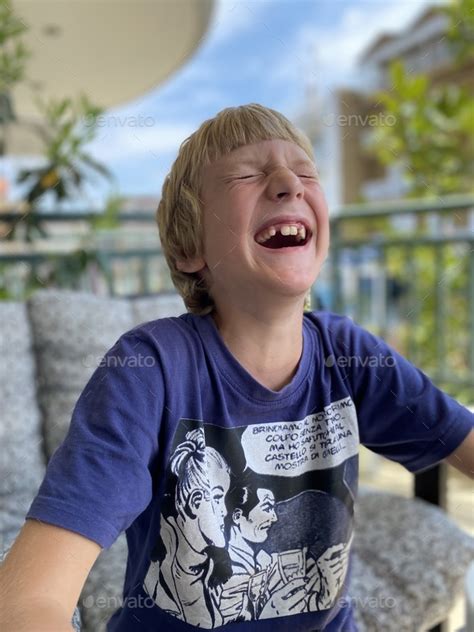 Boy laughing with open mouth, don’t have teeth Stock Photo by elenabednykh