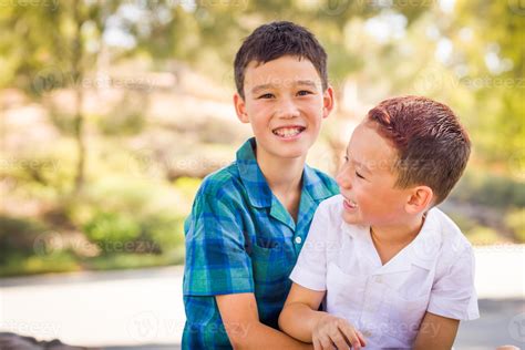 Outdoor Portrait Of Biracial Chinese And Caucasian Brothers Having Fun