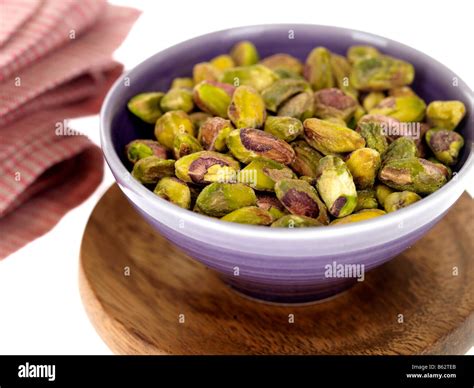 Fresh Shelled Green Pistachios Nuts In A Bowl Isolated Against A White