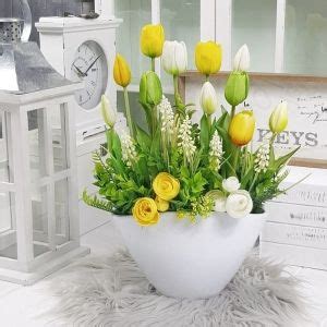 A White Vase Filled With Yellow And White Flowers On Top Of A Table