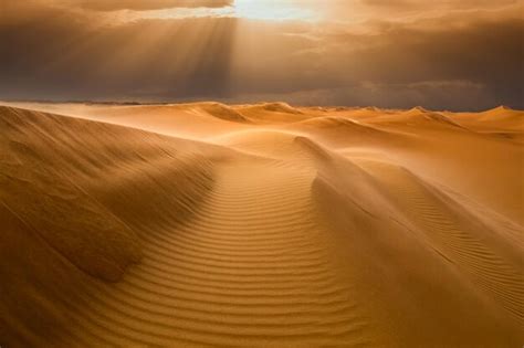 Puesta de sol sobre las dunas de arena en el desierto paisaje árido del