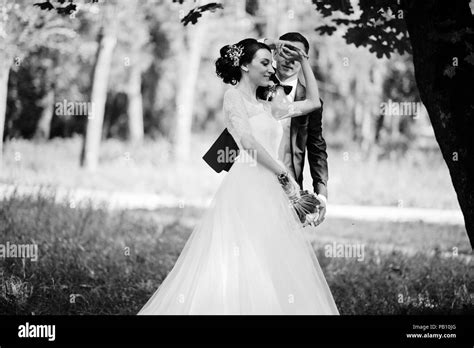 Beautiful wedding couple dancing outdoors in the park. Black and white ...