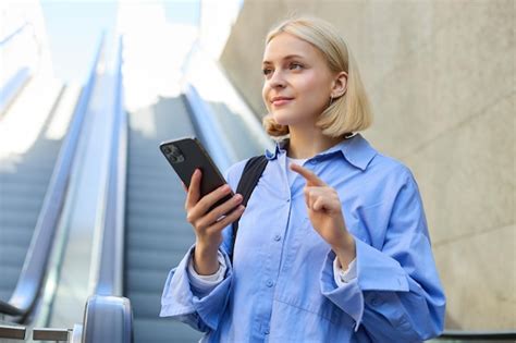 Portrait D une Belle Jeune Femme Blonde En Chemise Bleue Debout Près De L escalator Tenant Un