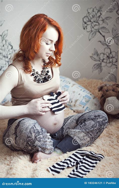 Red Haired Pregnant Woman In High Heeled Shoes And Fashionable Personal