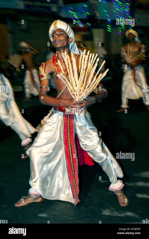 A Coconut Flower Dancer performs along a street at Kandy in Sri Lanka ...