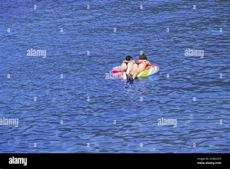 Zwei Junge Mädchen Schwimmen Auf Luftmatratze Im Meer Stockfotografie