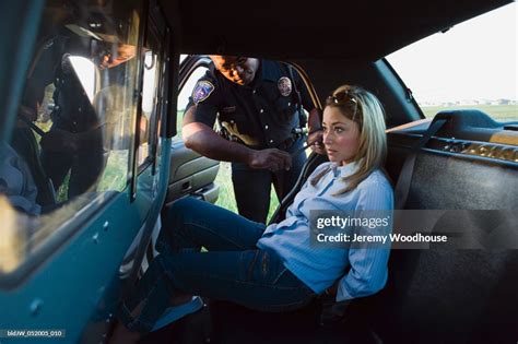 Mid Adult Woman Arrested By A Police Officer Sitting In A Police Car