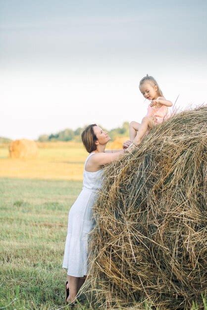 Una Madre Y Su Hija Juegan En Un Fardo De Heno Foto Premium