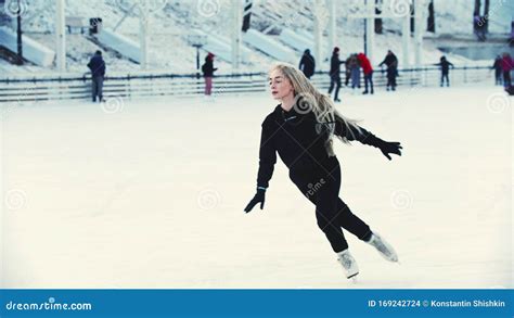 A Young Blonde Attractive Woman Professional Figure Skater Skating On