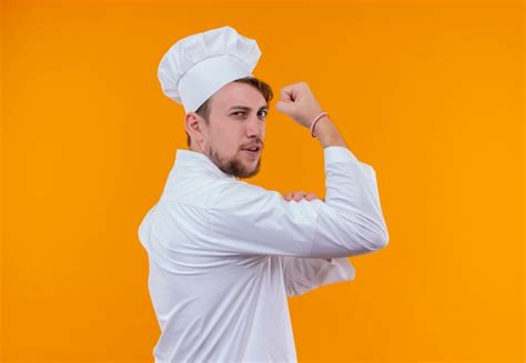 Un Confiado Joven Chef Barbudo Con Uniforme Blanco Mostrando Sus