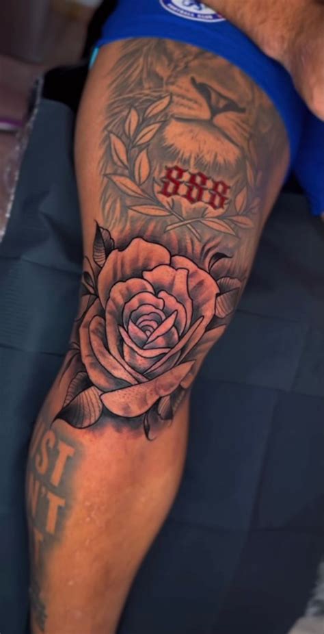 A Man With A Tattoo On His Leg Has A Rose In The Middle Of It