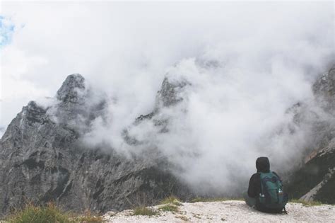 Premium Photo Man Overlooking Cloudy Rocky Mountains