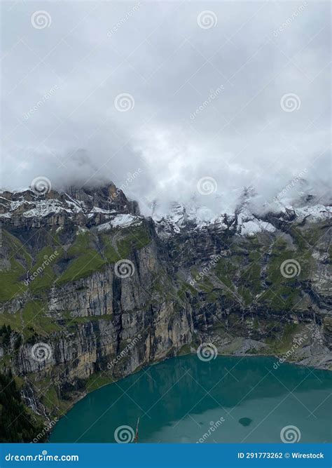 A Large Blue Lake Surrounded By Snow Covered Mountains And Forest