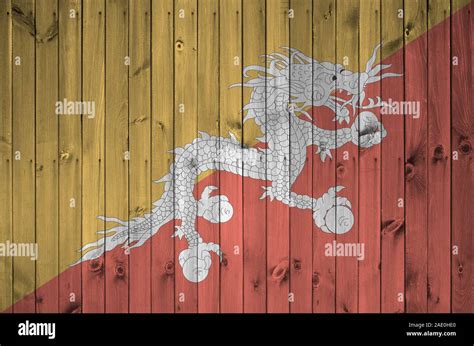 Bhutan Flag Depicted In Bright Paint Colors On Old Wooden Wall Close Up