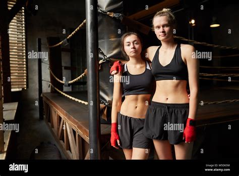 Portrait Of Two Female Boxers Posing Together Standing Against Boxing