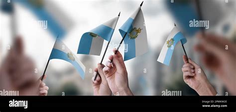 A Group Of People Holding Small Flags Of The San Marino In Their Hands