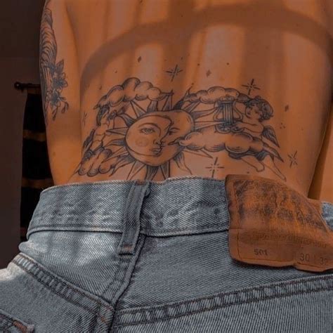 The Back Of A Person S Stomach With Tattoos On It