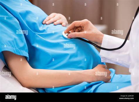 Cropped Shot Of Doctor With Stethoscope Listening Belly Of Pregnant