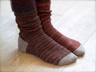 A Pair Of Socks That Are Sitting On The Floor In Front Of Someone S Feet