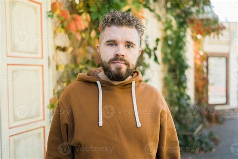 Outdoor portrait of young handsome smiling curly hair style man with ...