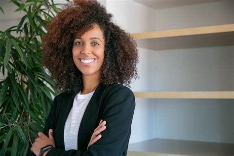 Mulher de negócios afro americana encaracolada em pé as mãos postas