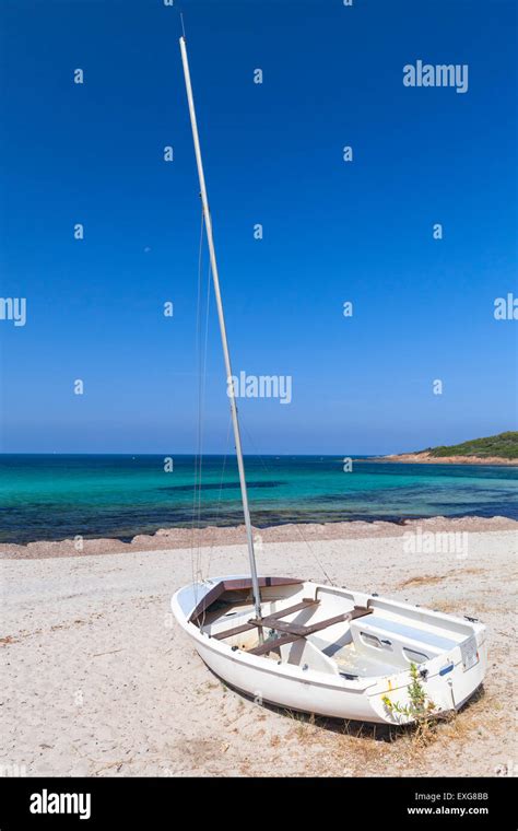 Small White Sailing Boat Lays On The Beach Corsica France Stock Photo