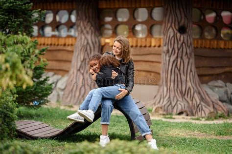 Mother And Adult Daughter Hugging And Having Fun Together In The Park