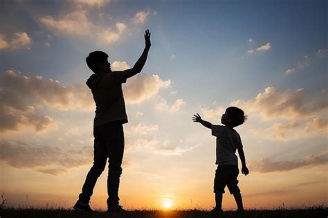 Silueta de pai jogando filho no céu pai e filho no fundo do pôr do sol