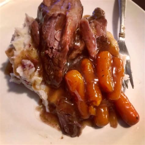 Slow Cooker Pot Roast With Gravy And Carrots Served Over Whipped