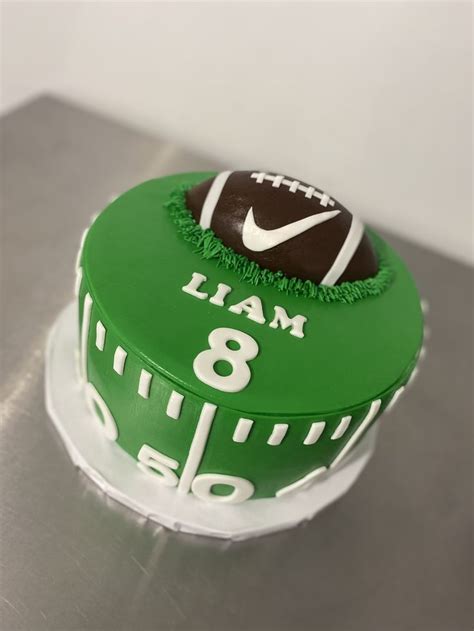 A Football Themed Birthday Cake With Green Frosting And White Lettering