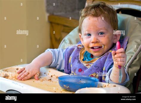 Messy Baby Covered In Food During Mealtime Stock Photo Alamy