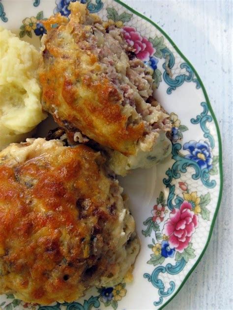 Two Meat Patties And Mashed Potatoes On A Floral Plate With Blue