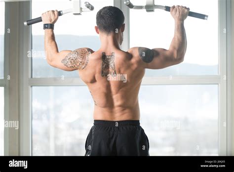 Hombre Deportista Haciendo Tirar Ups Chin Ups En El Gimnasio