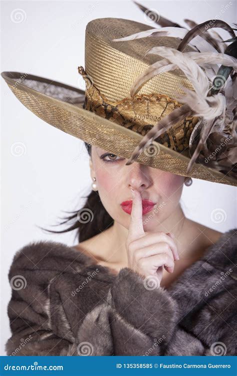 Beautiful Woman With Hat And Fur Coat And Finger In Her Mouth Pointing