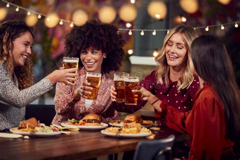 Multi Cultural Group Of Female Friends Enjoying Night Out Eating Meal