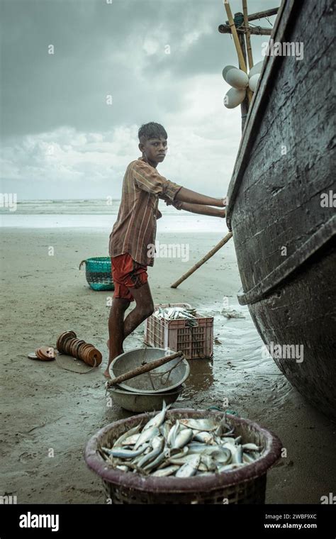 Fisherman By His Boat On The Beach With The Catch Of The Day During A