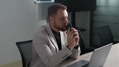 Serious Pensive Business Man Holding Smartphone Sitting At Office Desk