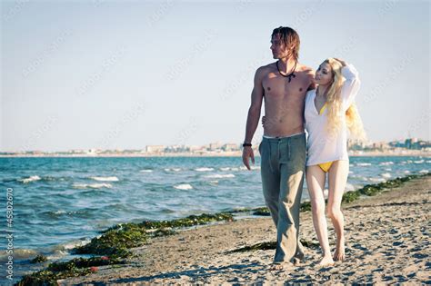 Romantic couple at the beach walking together. Stock Photo | Adobe Stock